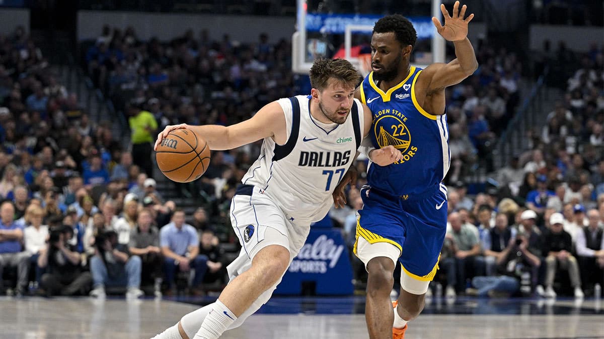 Dallas Mavericks guard Luka Doncic (77) \brings the ball up court past Golden State Warriors forward Andrew Wiggins (22) during the first quarter at the American Airlines Center.