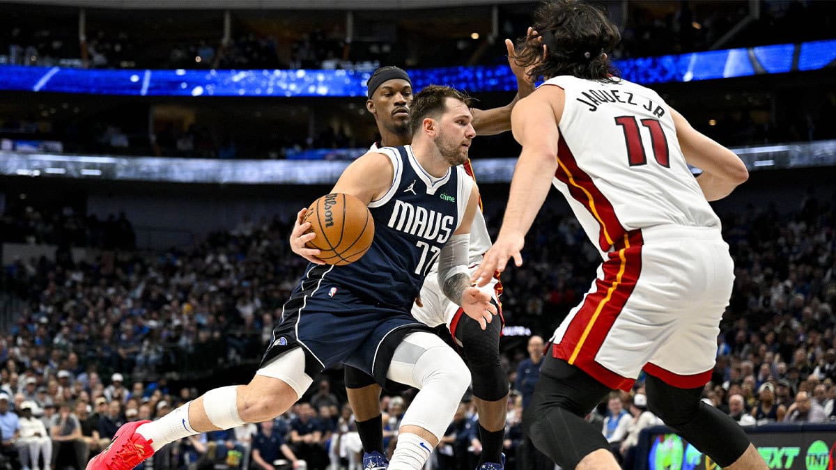 Dallas Mavericks guard Luka Doncic (77) looks the ball past Miami Heat forward Jimmy Butler (22) and guard Jaime Jaquez Jr. (11) during the second half at the American Airlines Center.