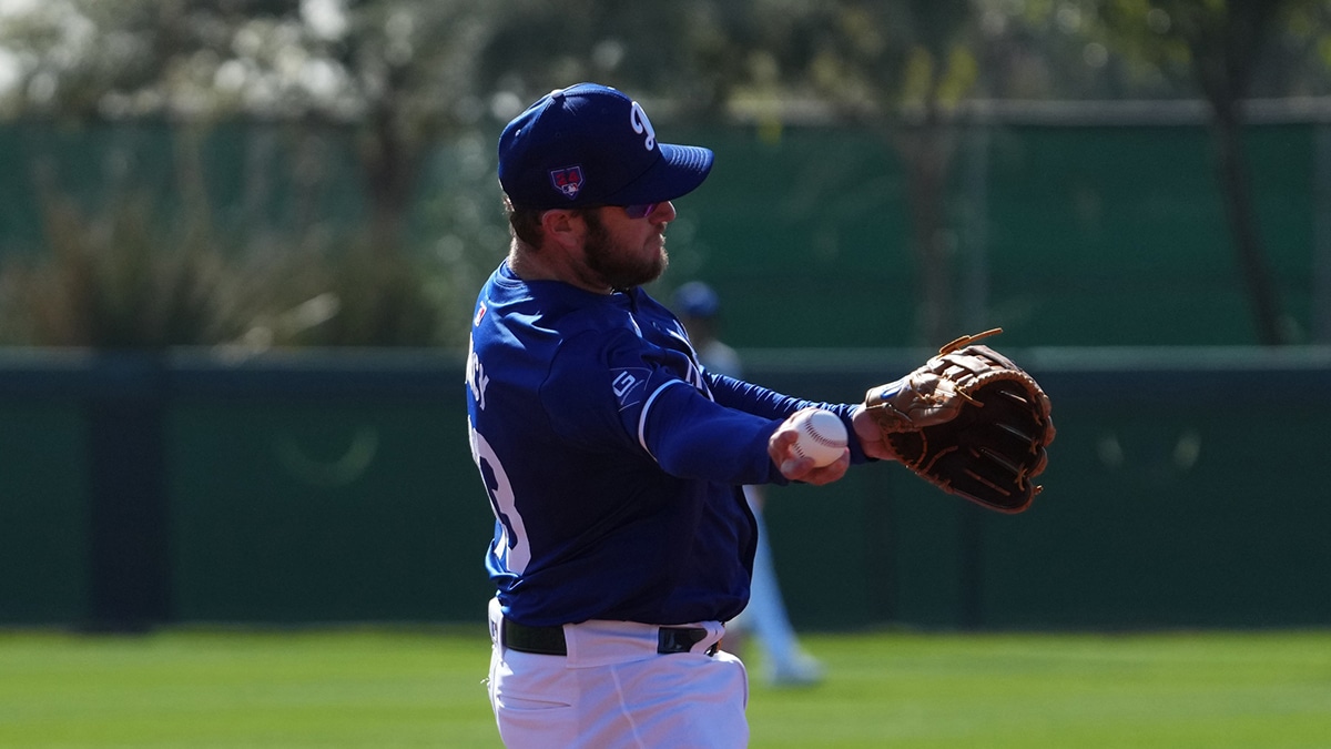 Los Angeles Dodgers third baseman Max Muncy (13) throws during a Spring Training workout at Camelback Ranch