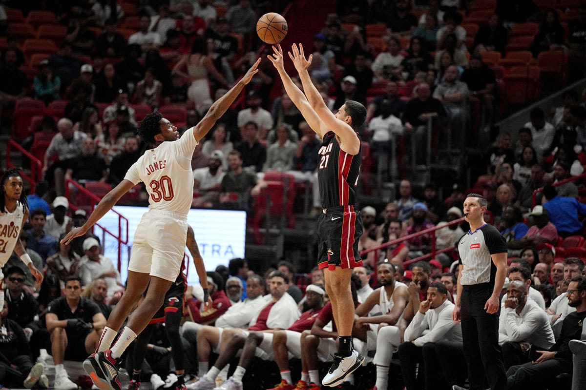 Miami Heat forward Cole Swider (21) takes a shot over the outstretched arms of Cleveland Cavaliers center Damian Jones (30) during the second half at Kaseya Center. 