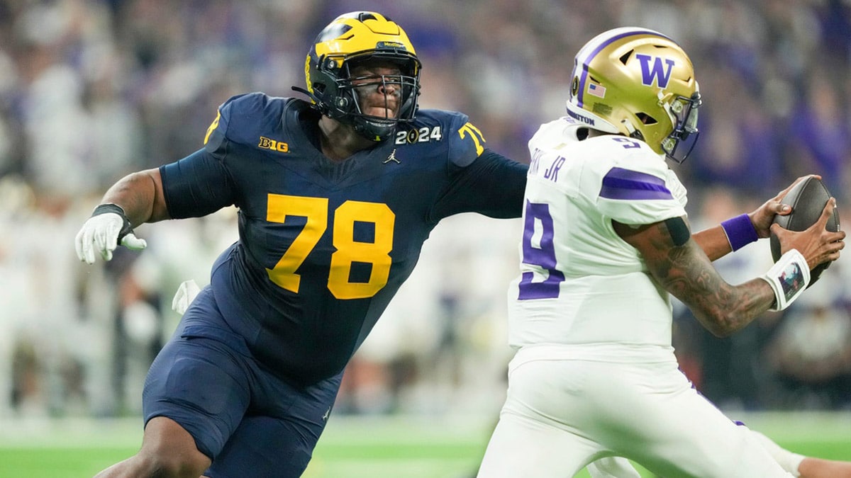 Michigan defensive lineman Kenneth Grant (78) reaches out to sack Washington quarterback Michael Penix Jr. (9) in the second quarter during the College Football Playoff national championship game against Washington at NRG Stadium