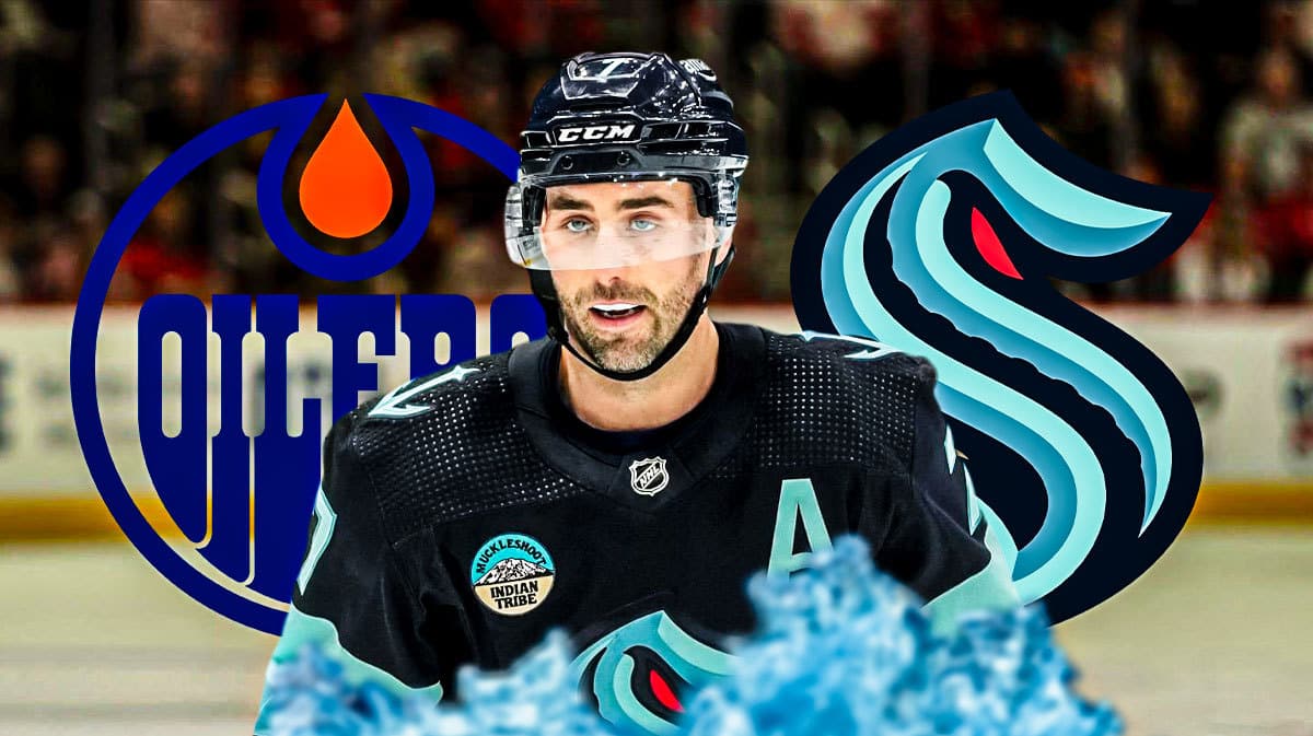 Jordan Eberle looking stern, EDM Oilers and SEA Kraken logo, hockey rink in background