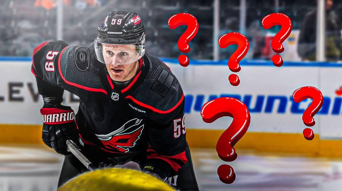 Jake Guentzel in CAR Hurricanes jersey, 3-5 question marks, hockey rink in background