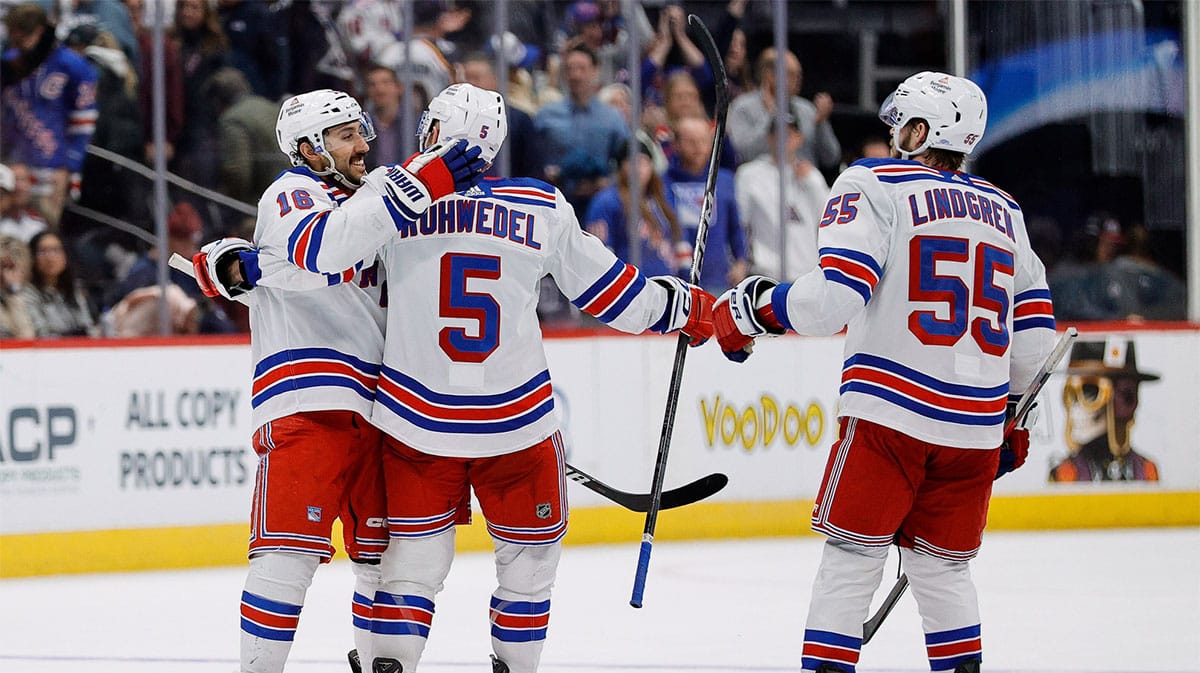 New York Rangers center Vincent Trocheck (16) celebrates with defenseman Chad Ruhwedel (5) and defenseman Ryan Lindgren (55) after the game against the Colorado Avalanche at Ball Arena.
