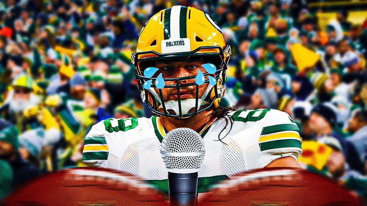 David Bakhtiari with a tear on his face in front of microphones and a crowd of Packers fans as the background