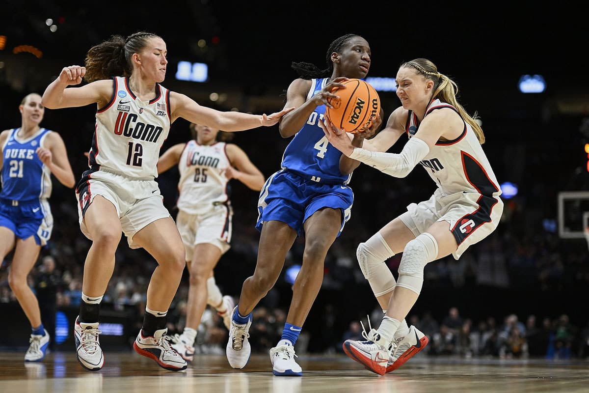 Duke Blue Devils guard Jadyn Donovan (4) is defended in the second half against UConn Huskies guard Ashlynn Shade (12) and guard Paige Bueckers (5) in the semifinals of the Portland Regional of the 2024 NCAA Tournament at the Moda Center. 