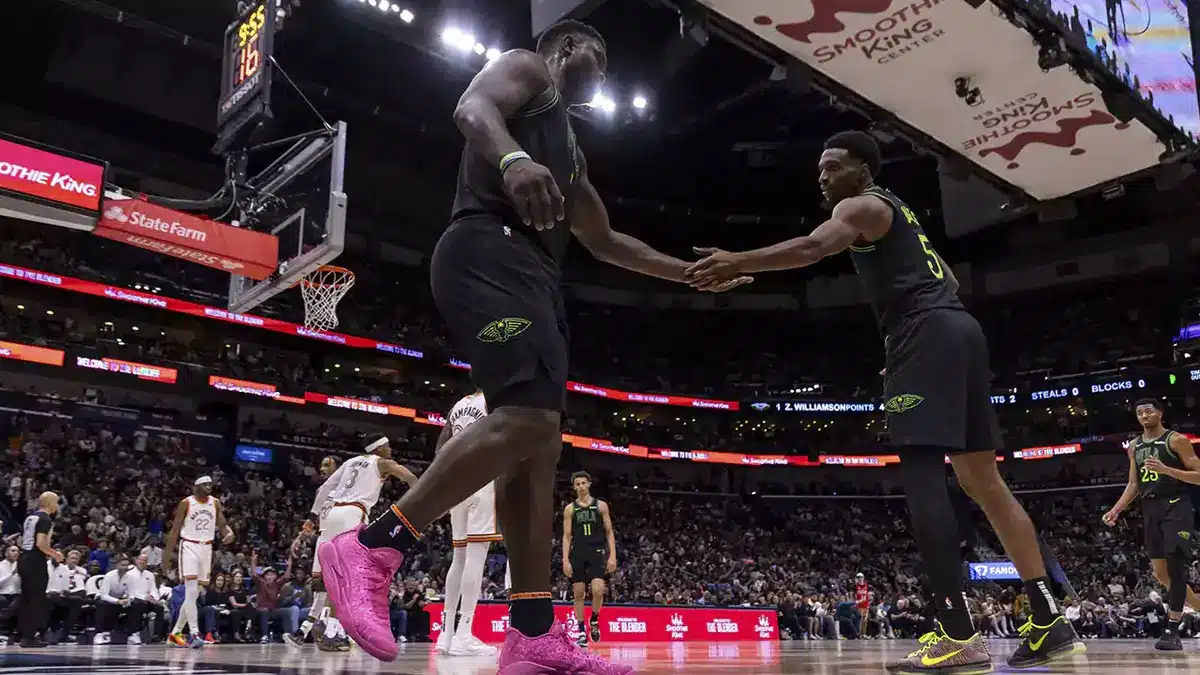 New Orleans Pelicans forward Zion Williamson (1) slaps hands with forward Herbert Jones (5) after being fouled by San Antonio Spurs forward Zach Collins (23) during the first half at the Smoothie King Center.