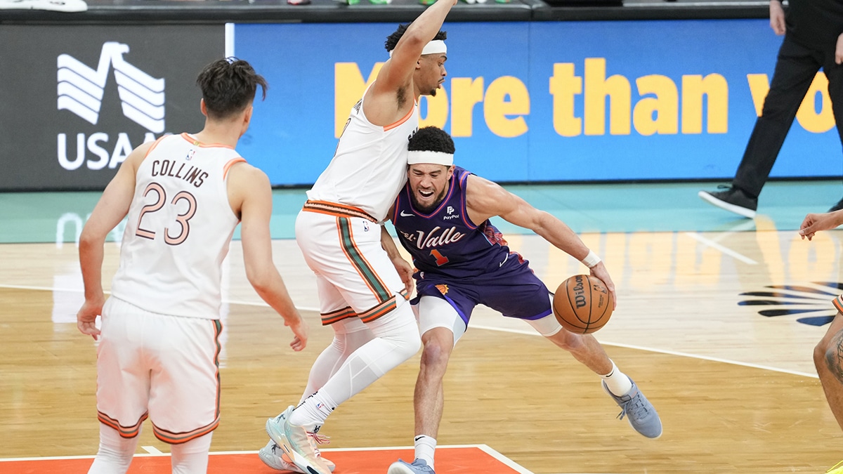 Phoenix Suns guard Devin Booker (1) dribbles against San Antonio Spurs forward Keldon Johnson (3) in the second half at Frost Bank Center. 