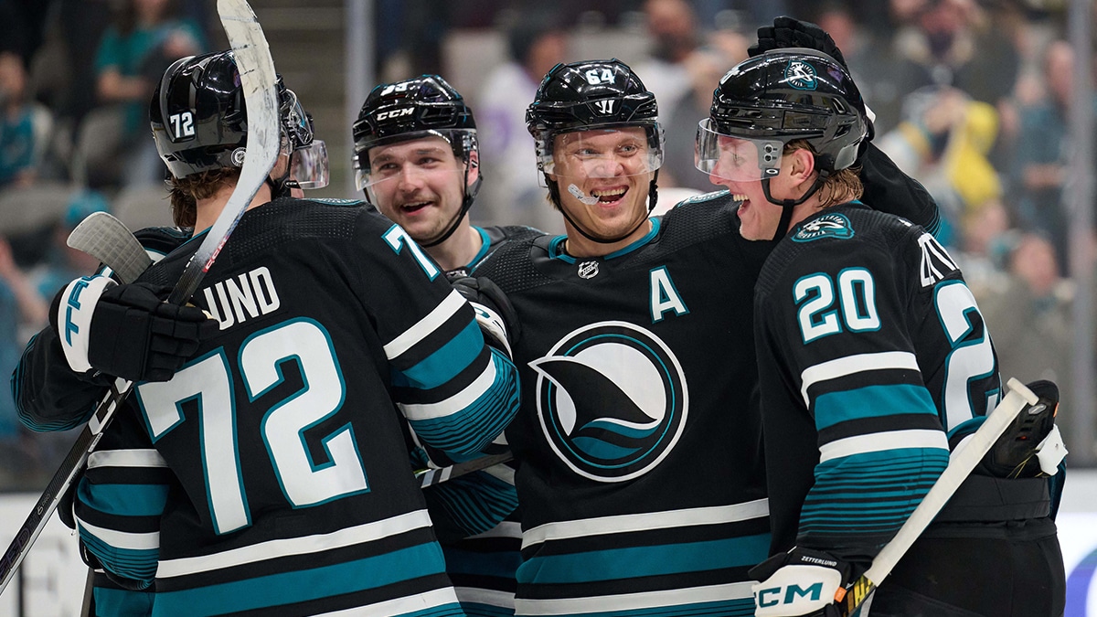 San Jose Sharks left wing Fabian Zetterlund (20) celebrates with center Mikael Granlund (64) and San Jose Sharks defenseman Kyle Burroughs (4) after scoring a goal against the Chicago Blackhawks during the second period at SAP Center at San Jose.