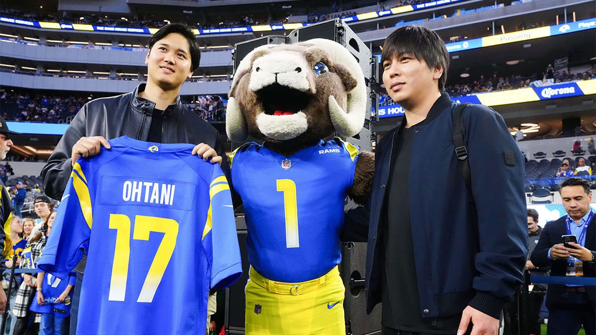 Los Angeles Dodgers player Shohei Ohtani (left) and interpreter Ippei Mizuhara (right) pose with Los Angeles Rams mascot Rampage (center) at SoFi Stadium. 