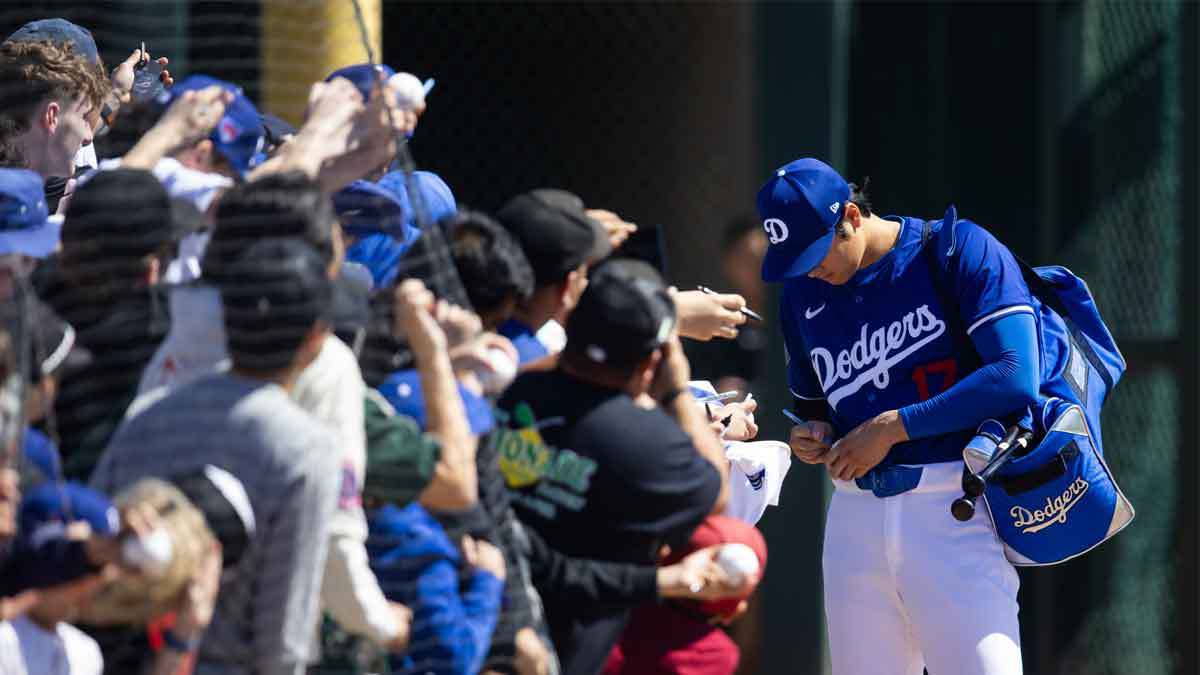Los Angeles Dodgers designated hitter Shohei Ohtani signs autographs against the Seattle Mariners during a spring training game at Camelback Ranch-Glendale.