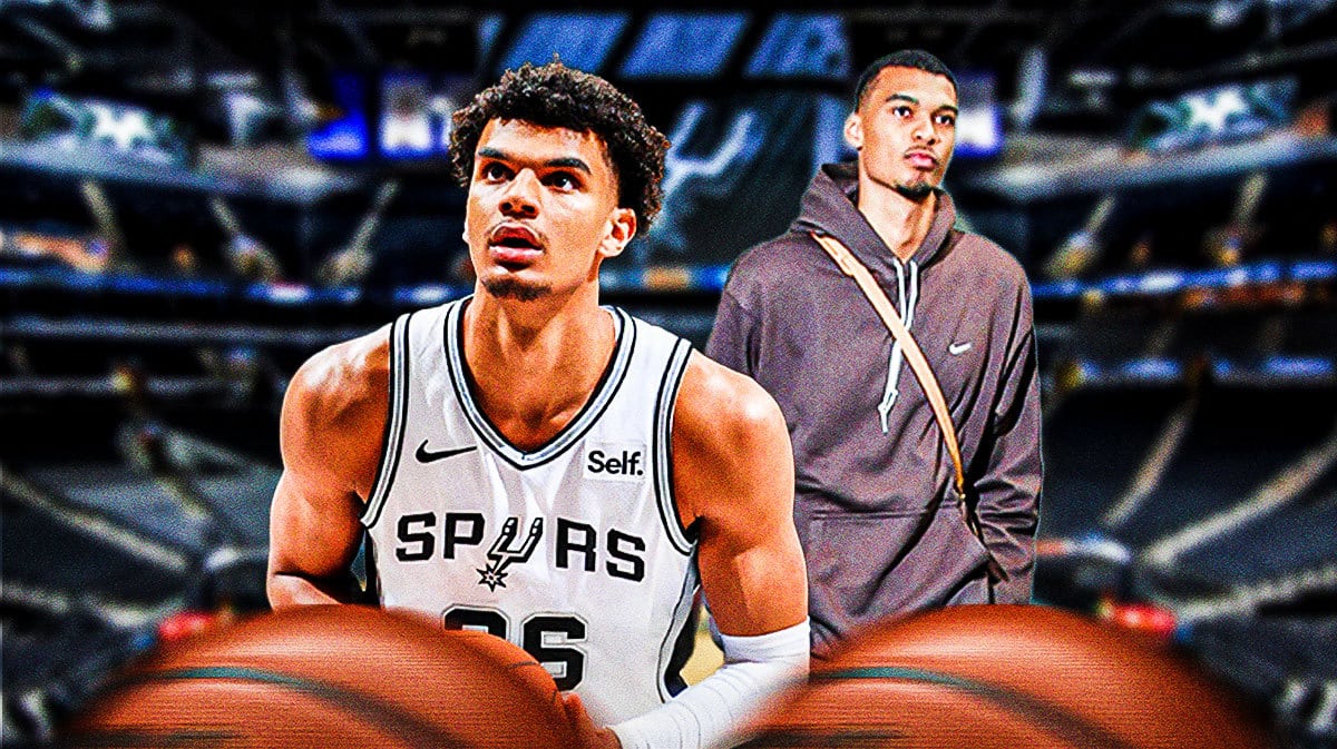 Spurs' Dominick Barlow in foreground with Victor Wembanyama in street clothes in the background