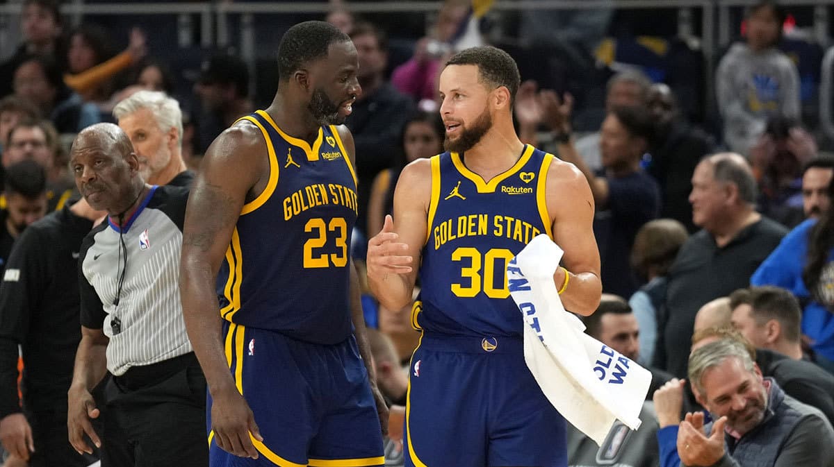 Golden State Warriors forward Draymond Green (23) and guard Stephen Curry (30) talk during overtime against the Los Angeles Lakers at Chase Center.