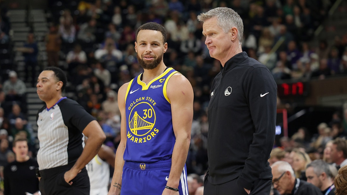 Golden State Warriors guard Stephen Curry (30) and head coach Steve Kerr talk on the sideline during the first quarter against the Utah Jazz at Delta Center.