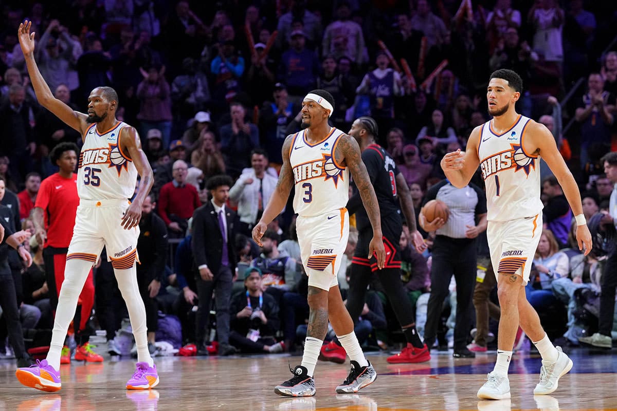 Phoenix Suns forward Kevin Durant (35) and Phoenix Suns guard Bradley Beal (3) and Phoenix Suns guard Devin Booker (1) reacts during the second half of the game against the Chicago Bulls at Footprint Center.