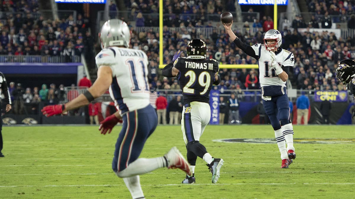 New England Patriots quarterback Tom Brady (12) throws to wide receiver Julian Edelman (11) as Baltimore Ravens safety Earl Thomas III (29) applies pressure at M&T Bank Stadium.