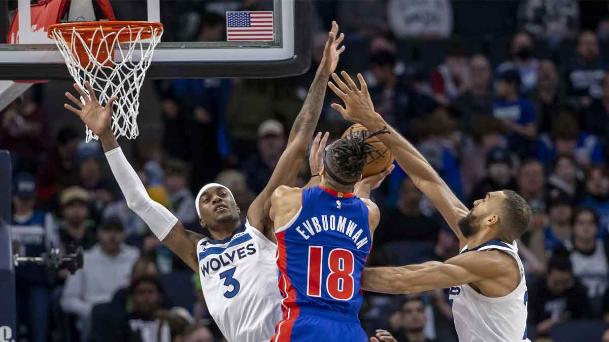 Detroit Pistons forward Tosan Evbuomwan (18) attempts to shoot the ball as Minnesota Timberwolves forward Jaden McDaniels (3) and Minnesota Timberwolves center Rudy Gobert (27) play defense in the first half at Target Center