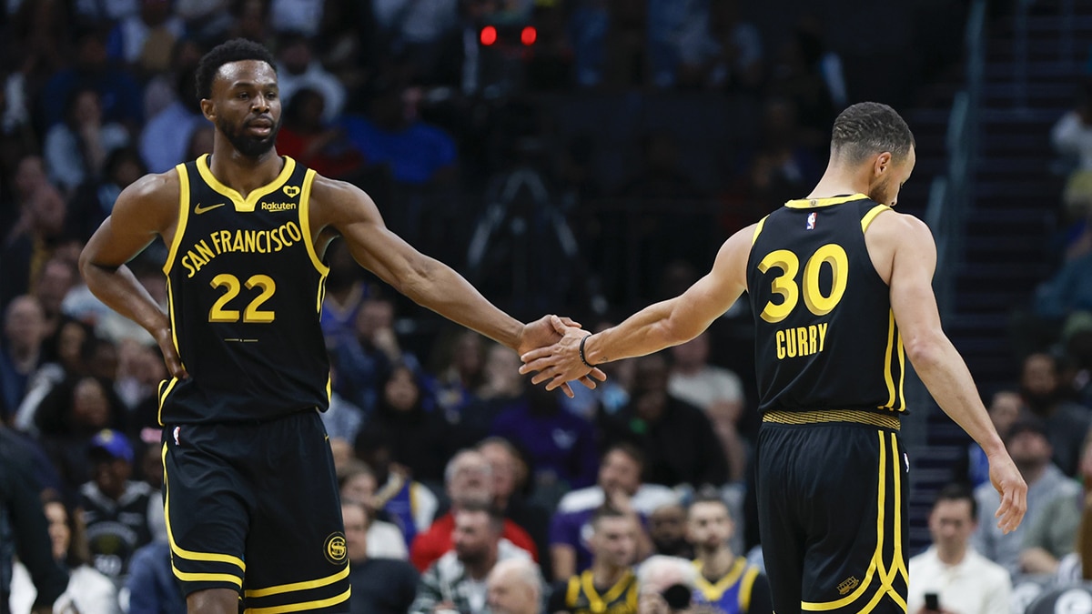 Golden State Warriors forward Andrew Wiggins (22) celebrates with Golden State Warriors guard Stephen Curry (30) after scoring against the Charlotte Hornets during the first quarter at Spectrum Center.