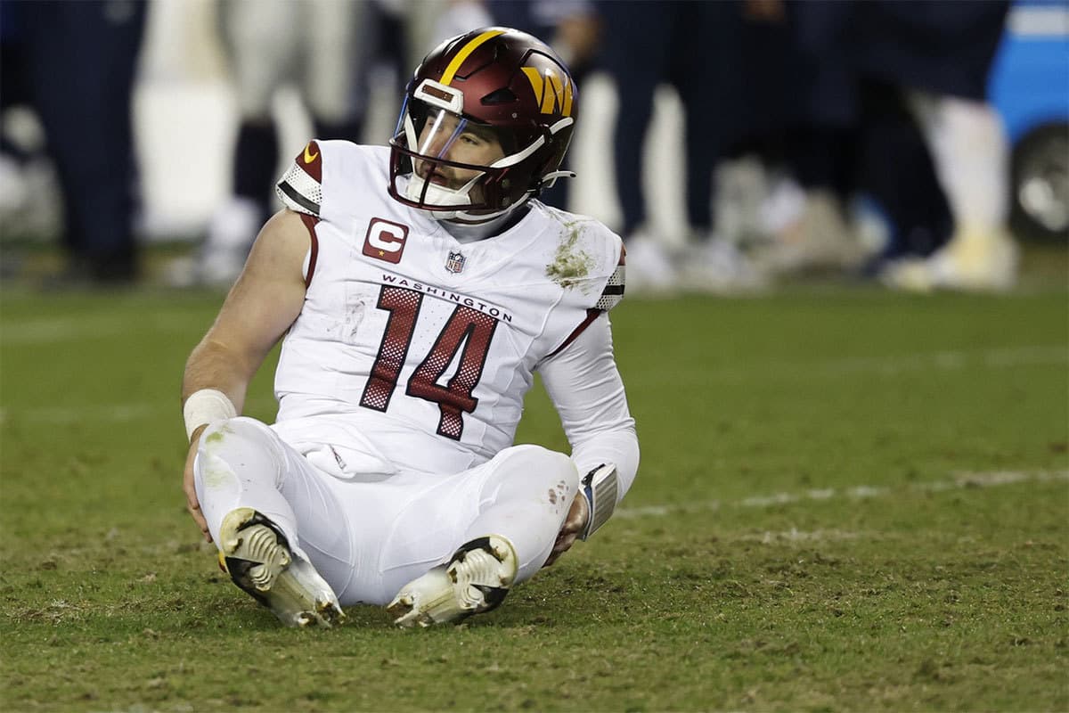 Washington Commanders quarterback Sam Howell (14) sits on the field after throwing an interception against the Dallas Cowboys during the third quarter at FedExField. 