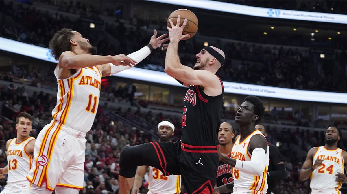 Atlanta Hawks guard Trae Young (11) defends Chicago Bulls guard Alex Caruso (6) during the first quarter during a play-in game of the 2024 NBA playoffs at United Center.