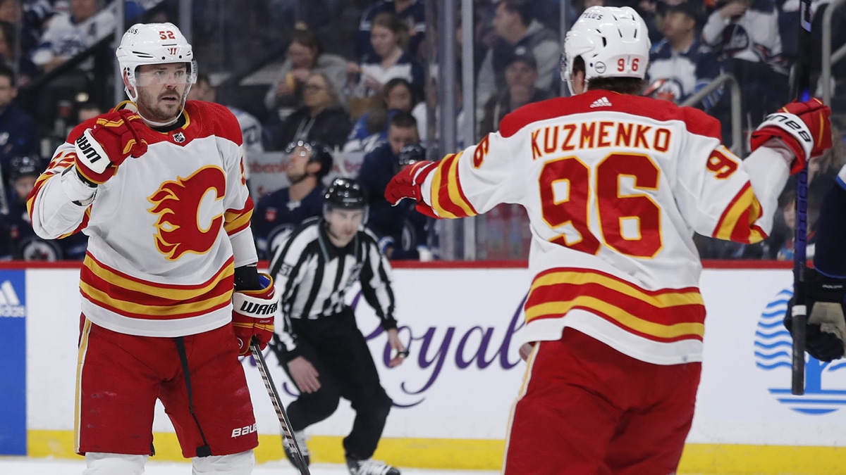 Calgary Flames defenseman MacKenzie Weegar (52) celebrates his first period goal with Calgary Flames left wing Andrei Kuzmenko (96) against the Winnipeg Jets at Canada Life Centre