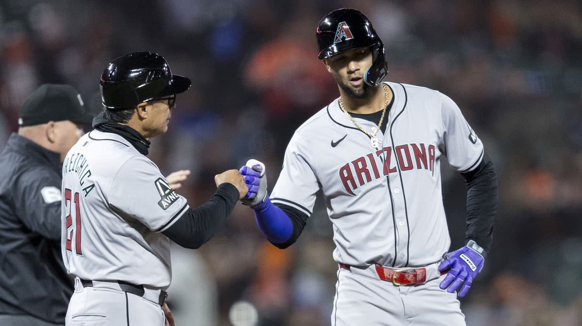 Arizona Diamondbacks first base Christian Walker (53) is congratulated by third base coach Tony Perezchica (21) after scoring against the San Francisco Giants during the seventh inning at Oracle Park. 