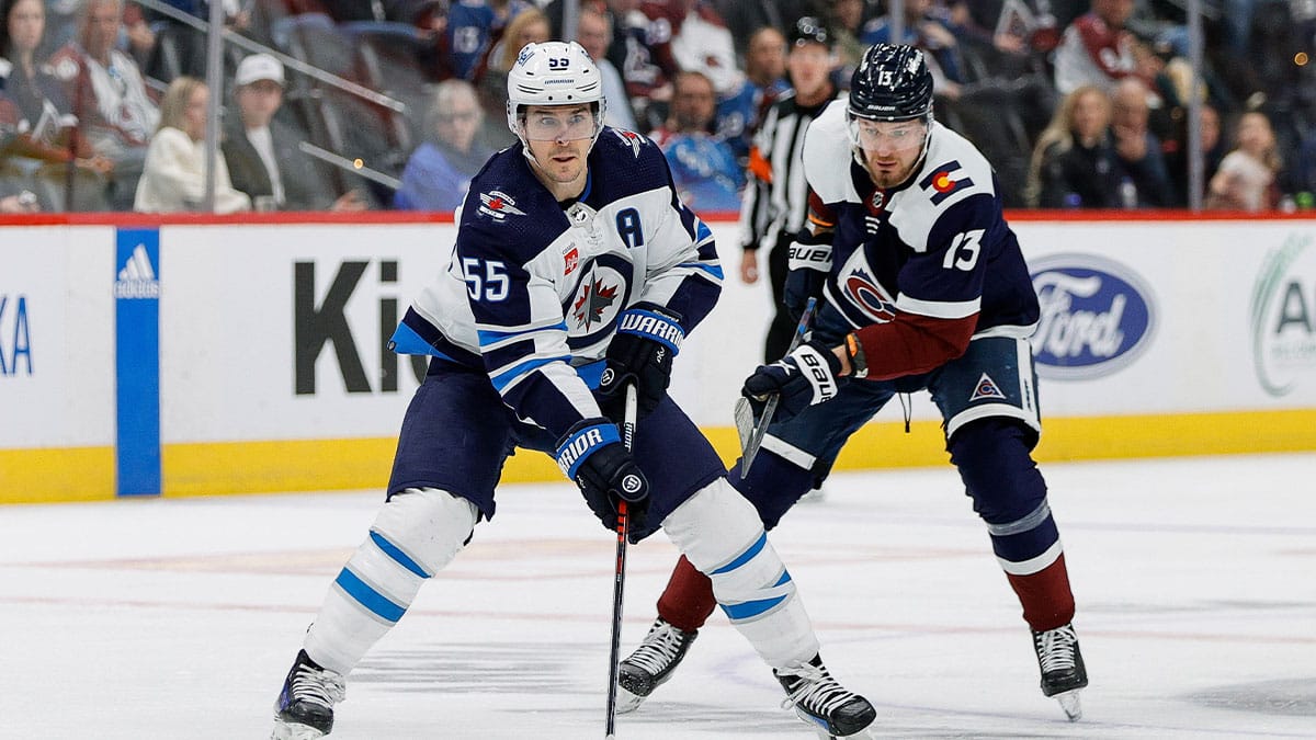 Winnipeg Jets center Mark Scheifele (55) controls the puck ahead of Colorado Avalanche right wing Valeri Nichushkin (13) in the third period at Ball Arena.