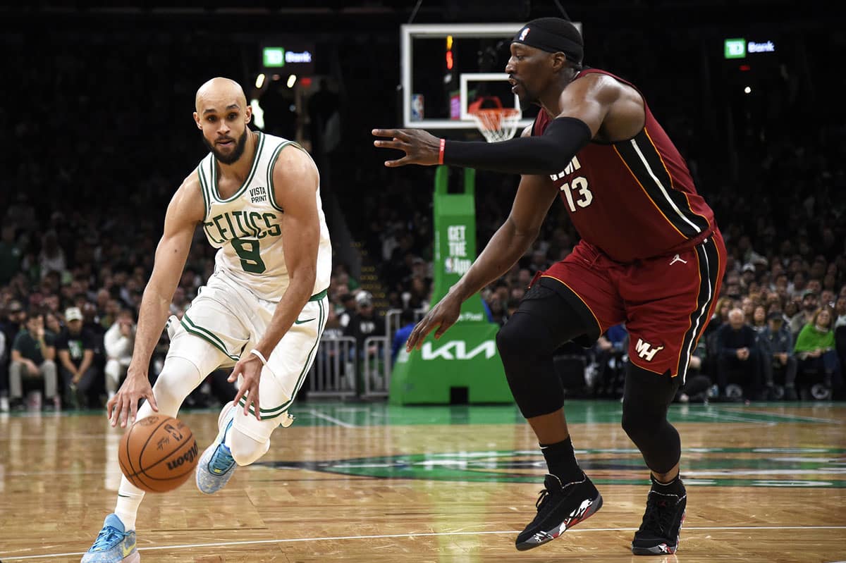 Boston Celtics guard Derrick White (9) controls the ball while Miami Heat center Bam Adebayo (13) defends during the second half in game one of the first round for the 2024 NBA playoffs at TD Garden.