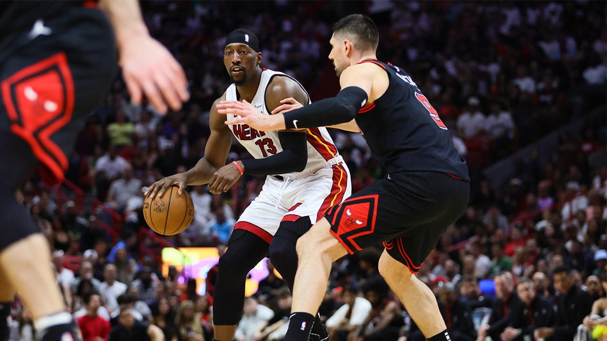 Miami Heat center Bam Adebayo (13) dribbles the basketball against Chicago Bulls center Nikola Vucevic (9) in the fourth quarter during a play-in game of the 2024 NBA playoffs at Kaseya Center.