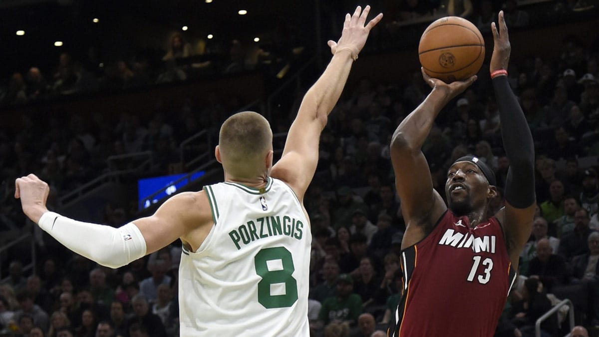 Miami Heat center Bam Adebayo (13) shoots the ball past Boston Celtics center Kristaps Porzingis (8) during the first half in game one of the first round for the 2024 NBA playoffs at TD Garden. 