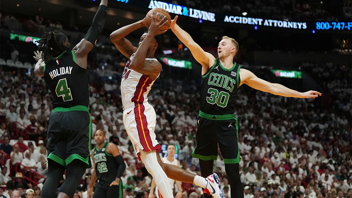 Miami Heat forward Haywood Highsmith (24) drives to the basket as Boston Celtics guard Jrue Holiday (4) and forward Sam Hauser (30) defend