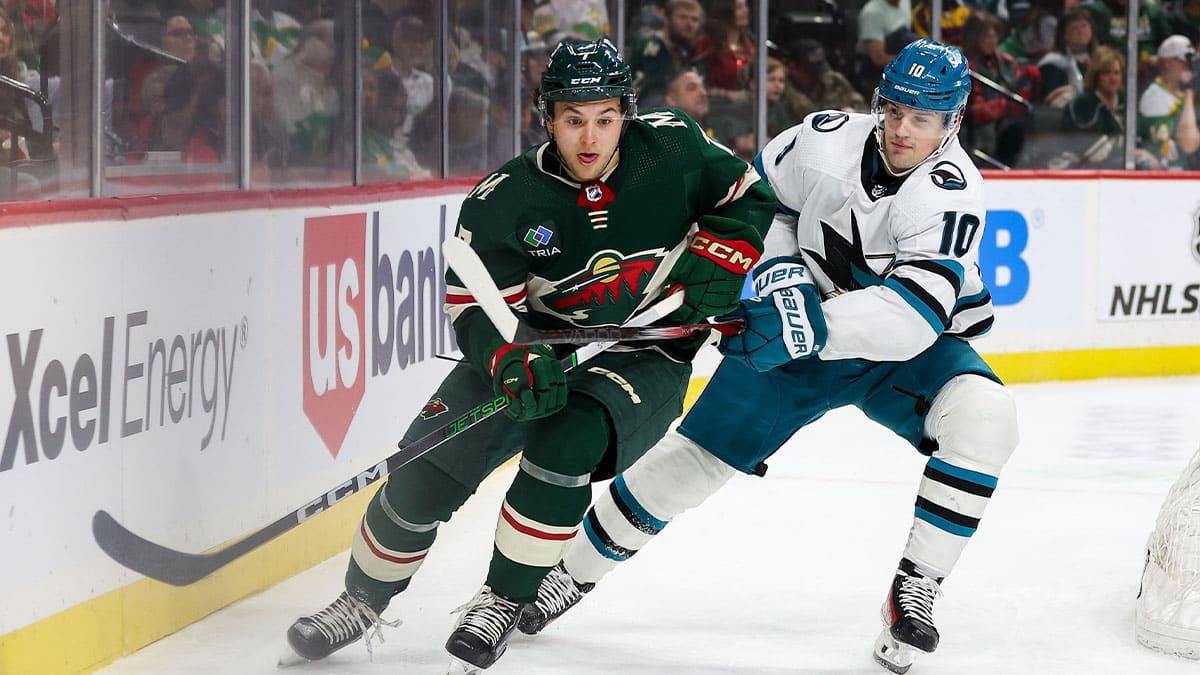 Minnesota Wild defenseman Brock Faber (7) and San Jose Sharks center Klim Kostin (10) compete for the puck during the first period at Xcel Energy Center.