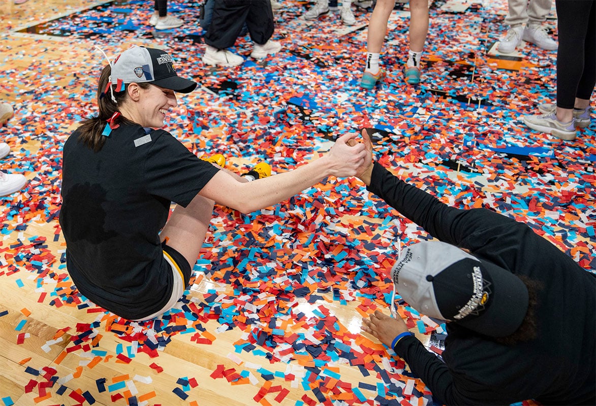Caitlin Clark celebrating in confetti after beating LSU in the Elite Eight