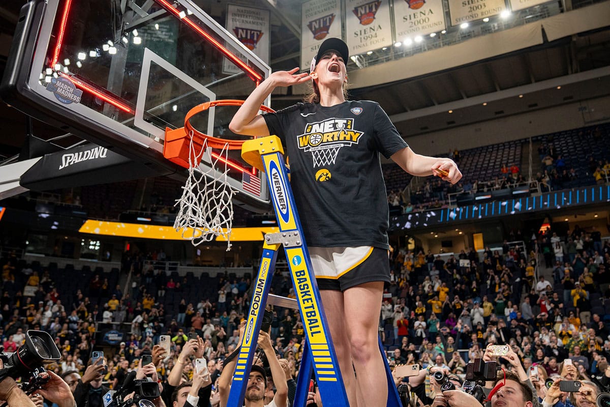 Iowa Hawkeyes guard Caitlin Clark (22) cuts down the net after beating LSU in the Elite 8 round of the NCAA Women's Basketball Tournament between Iowa and LSU