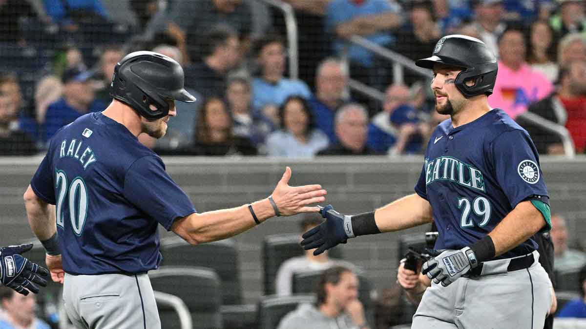 Seattle Mariners catcher Cal Raleigh (29) is greeted by pinch runner Luke Raley (20) after scoring them both by hitting a two run home run in the 10th inning against the Toronto Blue Jays at Rogers Centre. 