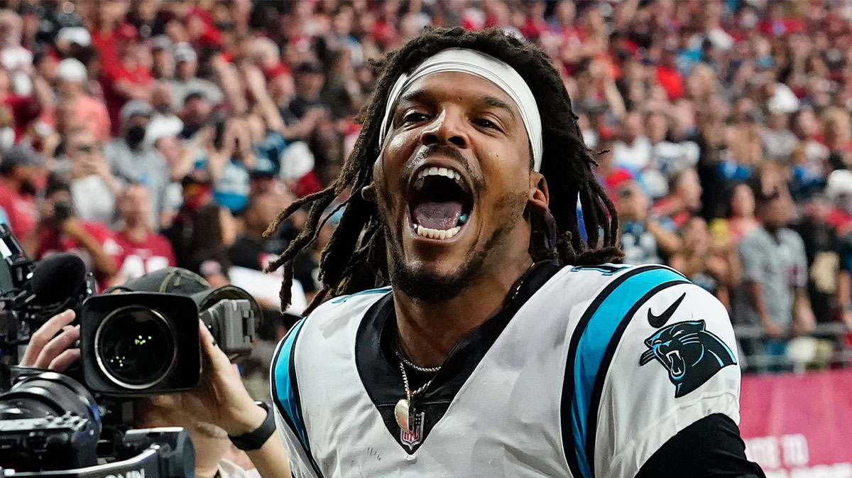 Carolina Panthers quarterback Cam Newton yells \"I'm back!\" after scoring a rushing touchdown against the Arizona Cardinals in a game in 2021.