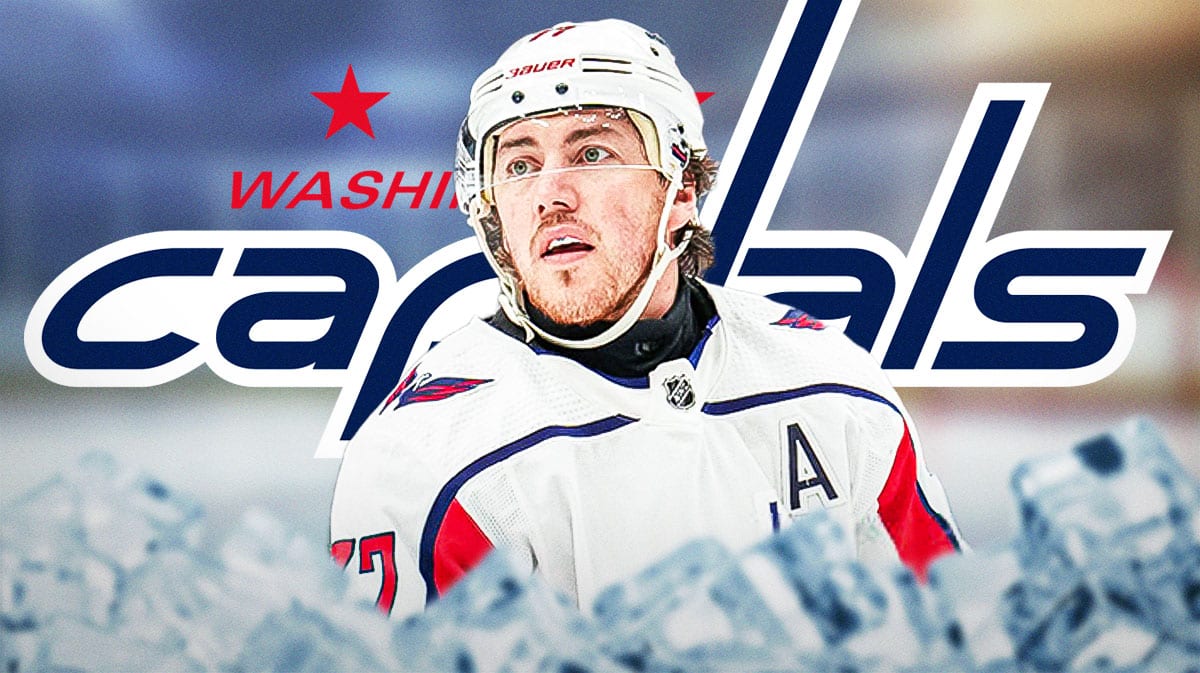 TJ Oshie in middle of image looking stern, Washington Capitals logo, hockey rink in background