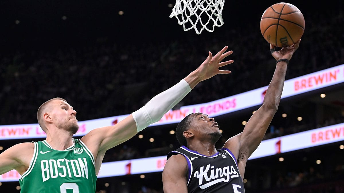 Sacramento Kings guard De'Aaron Fox (5) shoots a lay up against Boston Celtics center Kristaps Porzingis (8) during the second half at TD Garden.