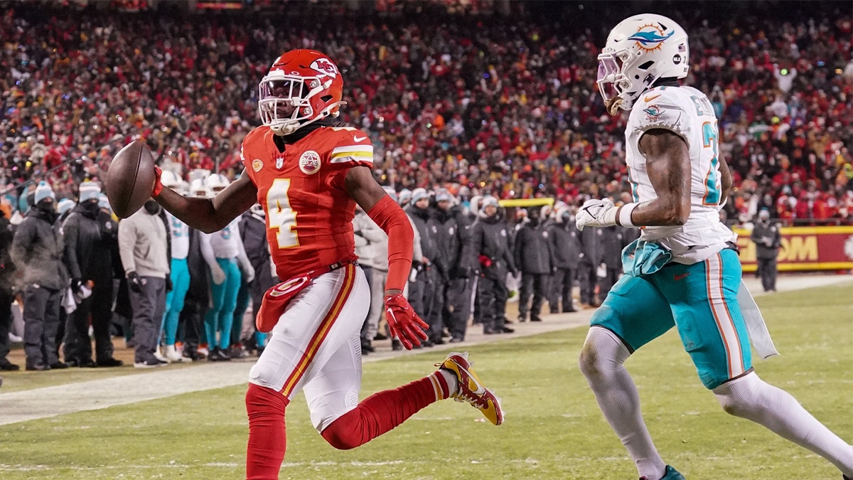 Kansas City Chiefs wide receiver Rashee Rice (4) scores a touchdown as Miami Dolphins safety DeShon Elliott (21) looks on in a 2024 AFC wild card game at GEHA Field at Arrowhead Stadium.