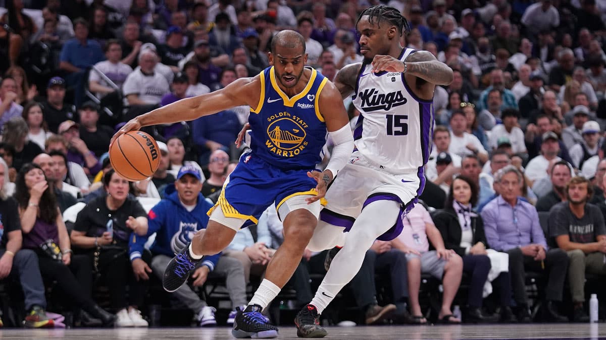 Golden State Warriors guard Chris Paul (3) dribbles the ball next to Sacramento Kings guard Davion Mitchell (15) in the second quarter during a play-in game of the 2024 NBA playoffs at the Golden 1 Center.