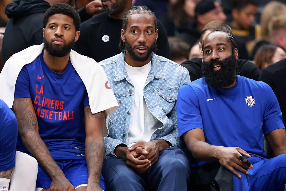 Los Angeles Clippers forward Paul George (13, left) and forward Kawhi Leonard (2, center) and guard James Harden (1, right) watch the game from the bench during the third quarter against the Utah Jazz at Crypto.com Arena