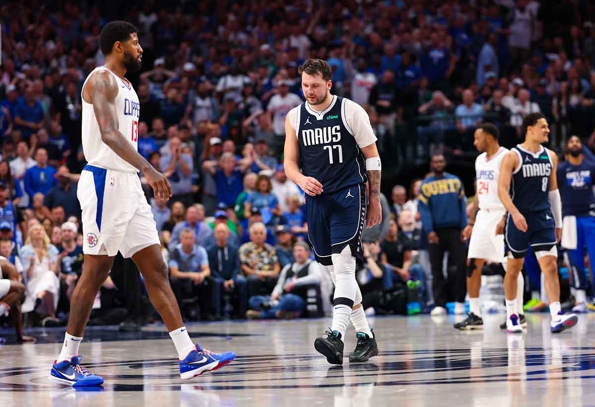 Dallas Mavericks guard Luka Doncic (77) reacts in front of LA Clippers forward Paul George (13) during the first half during game four of the first round for the 2024 NBA playoffs at American Airlines Center.