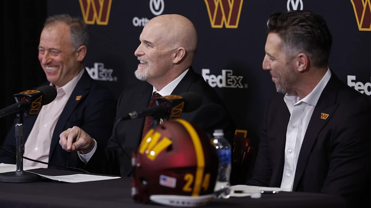 Washington Commanders majority owner Josh Harris (L) and Commanders general manager Adam Peters (R) laugh as Commanders head coach Dan Quinn (R) speaks during his introductory press conference at Commanders Park.