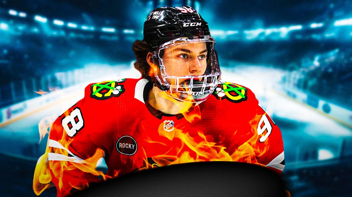 Connor Bedard in middle of image looking happy with fire around him, hockey rink in background, Chicago Blackhawks logo