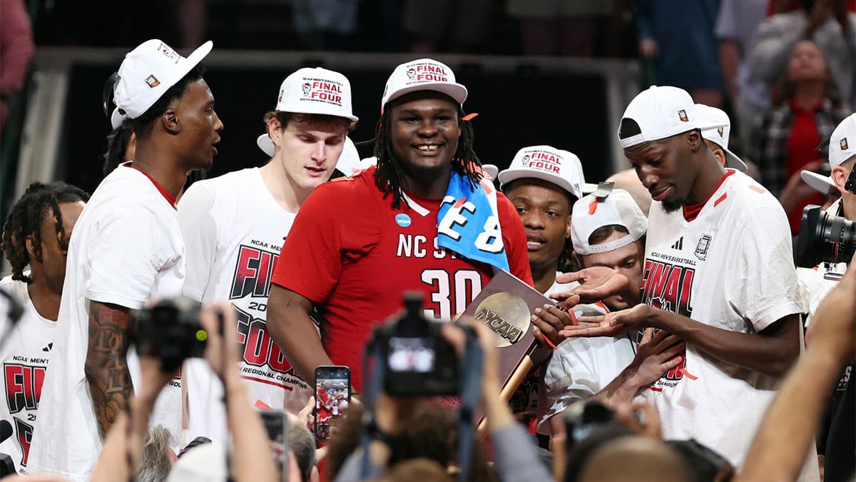 Mar 31, 2024; Dallas, TX, USA; North Carolina State Wolfpack forward DJ Burns Jr. (30) celebrates with the trophy after defeating the Duke Blue Devils in the finals of the South Regional of the 2024 NCAA Tournament at American Airline Center. 