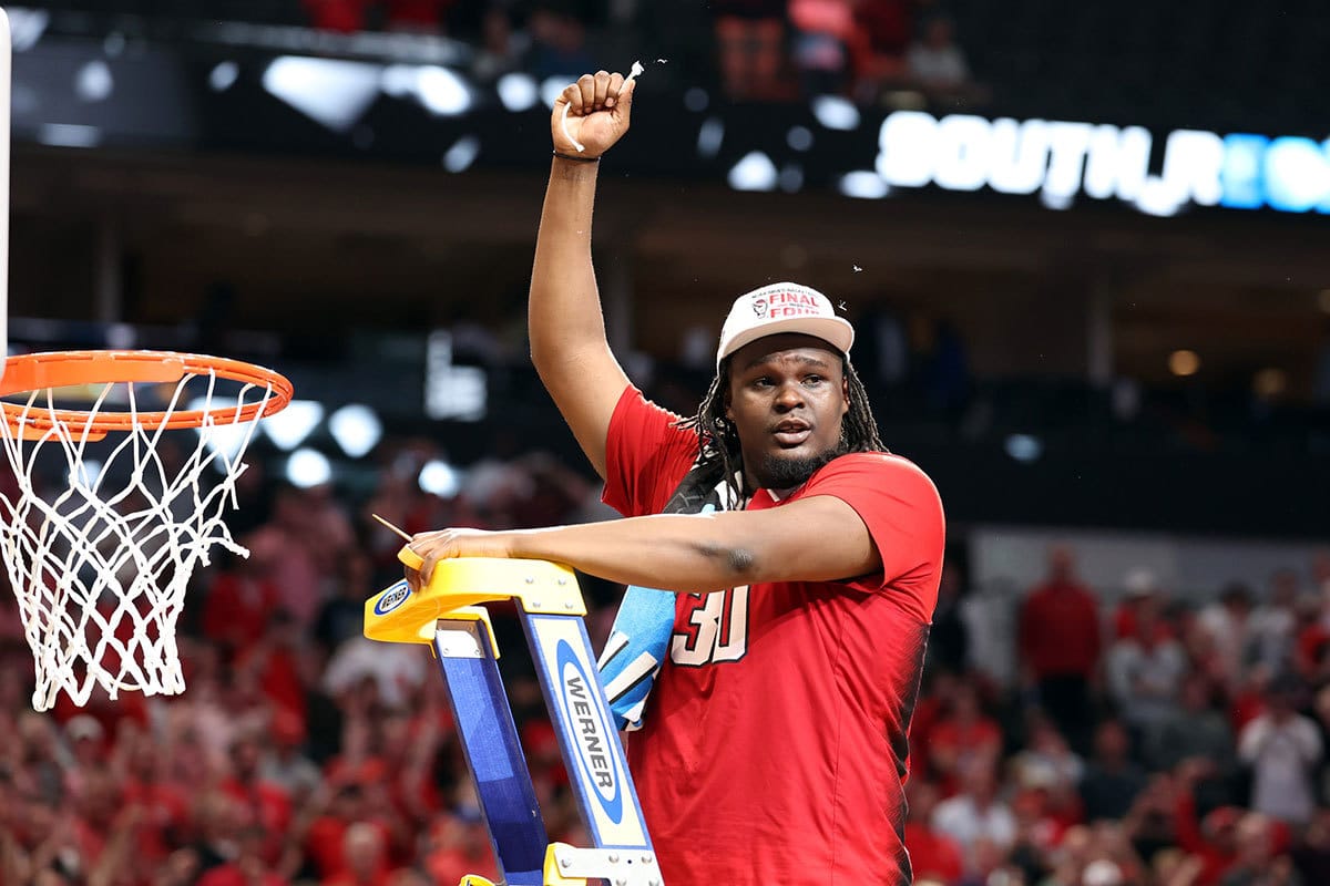 North Carolina State Wolfpack forward DJ Burns Jr. (30) cuts the net after defeating the Duke Blue Devils in the finals of the South Regional of the 2024 NCAA Tournament at American Airline Center. 
