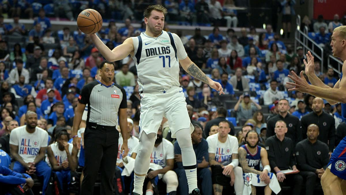 Apr 21, 2024; Los Angeles, California, USA; Dallas Mavericks guard Luka Doncic (77) saves the ball from going out of bounds in the first half during game one of the first round for the 2024 NBA playoffs against the Los Angeles Clippers at Crypto.com Arena. Mandatory Credit: Jayne Kamin-Oncea-USA TODAY Sports
