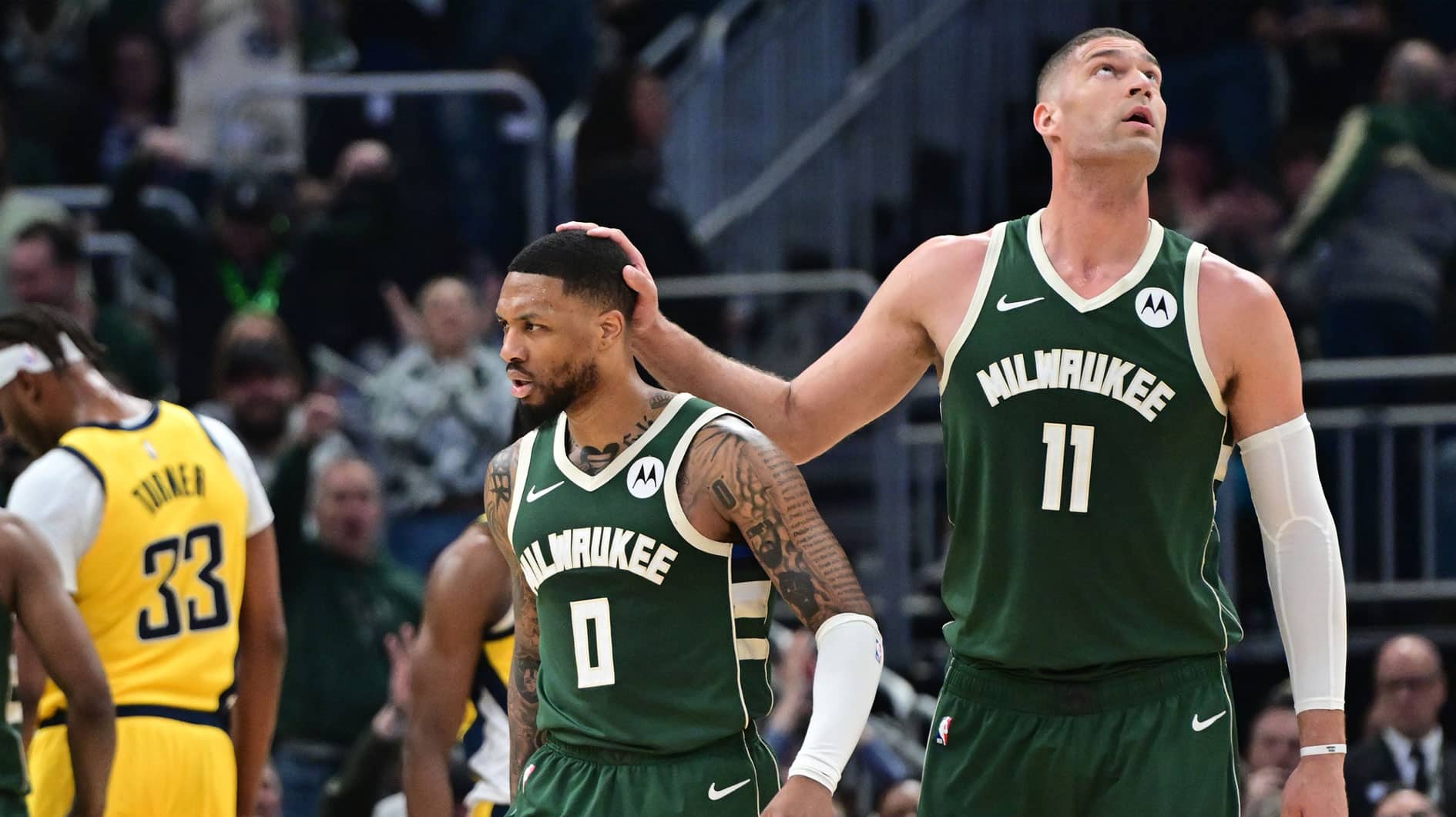 Milwaukee Bucks guard Damian Lillard (0) reacts with center Brook Lopez (11) after scoring a basket in the in the second quarter against the Indiana Pacers during game one of the first round for the 2024 NBA playoffs at Fiserv Forum