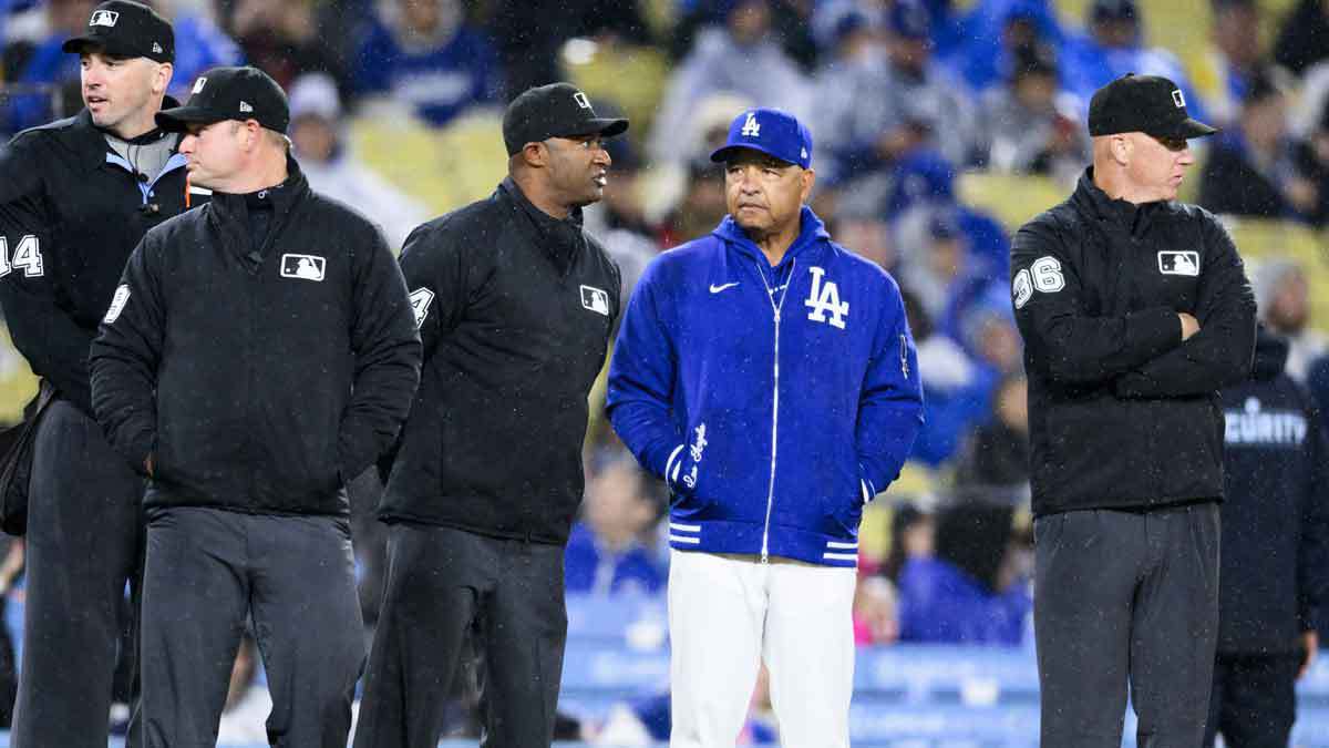 Los Angeles Dodgers manager Dave Roberts stand with MLB umpires before the fifth inning at Dodger Stadium. 
