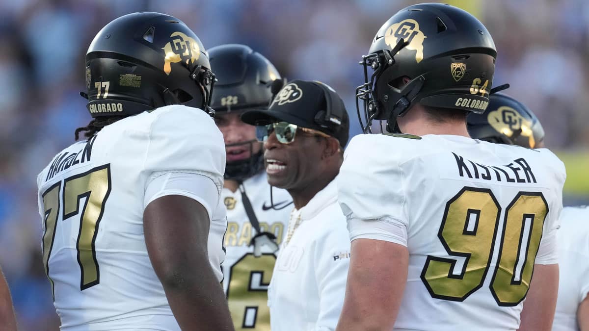 Colorado Buffaloes head coach Deion Sanders talks with offensive tackle Kareem Harden (77) in the first half against the UCLA Bruins at Rose Bowl